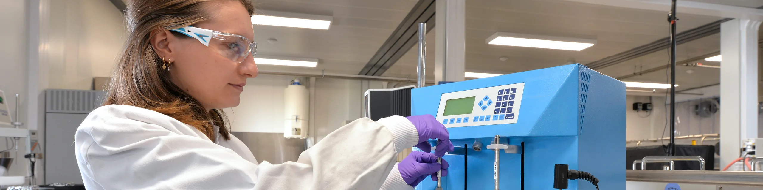técnica de laboratório olhando pelo microscópio